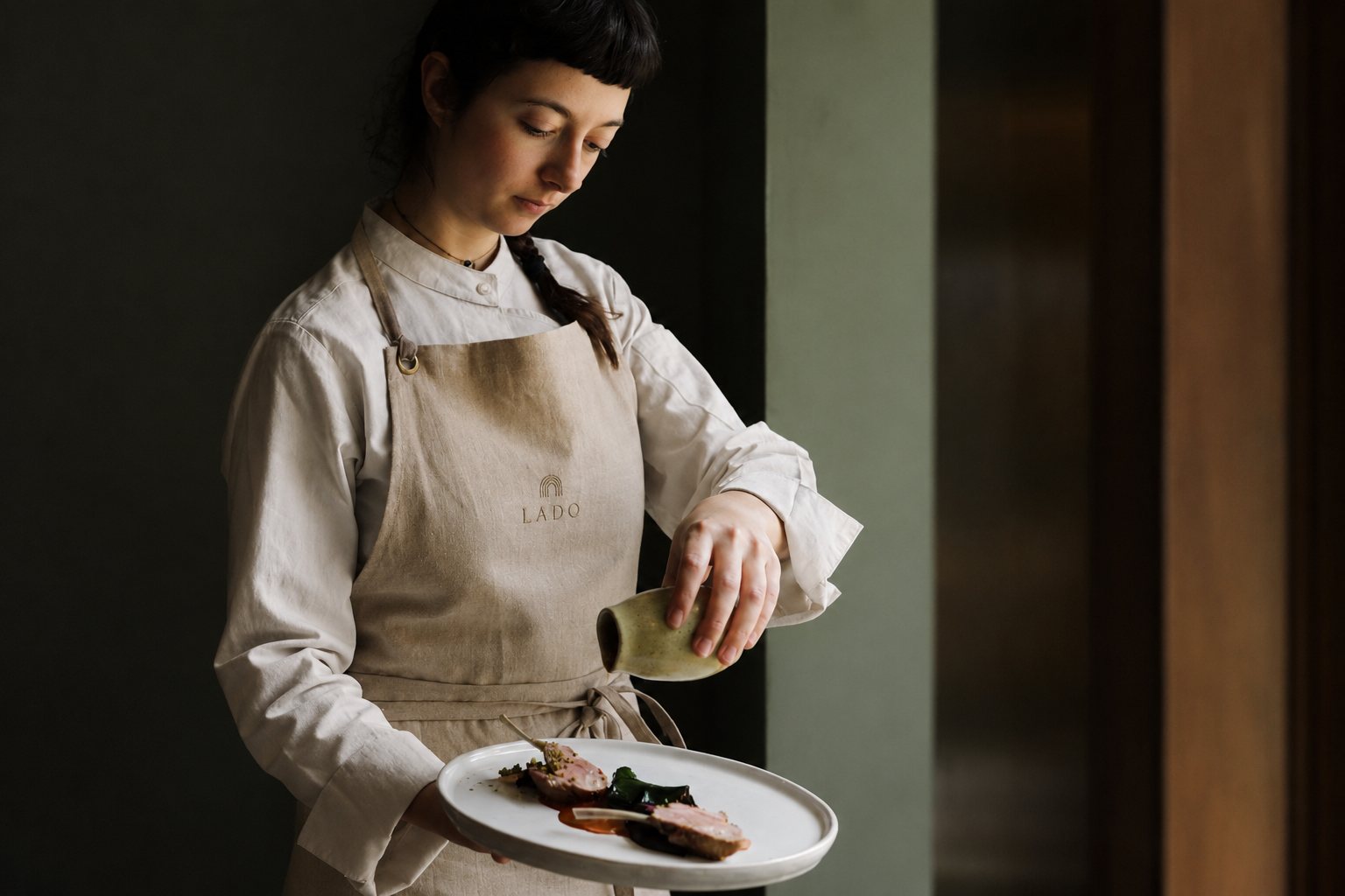 Chef finishing a Lado dish with careful attention